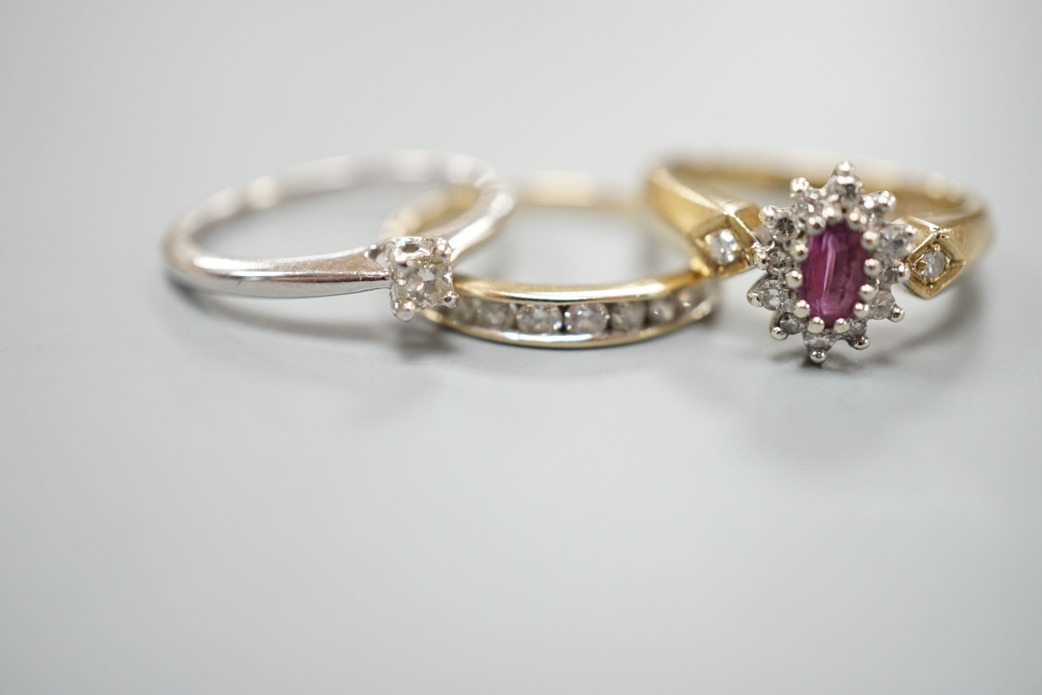 Three assorted 9ct gold and gem set dress rings including a solitaire diamond ring, size I, gross weight 5.8 grams.
